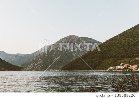 Coastal village on Bay of Kotor with mountains and calm sea at sunset Coastal village on Bay of Kotor with mountains and calm sea at sunset 139589220