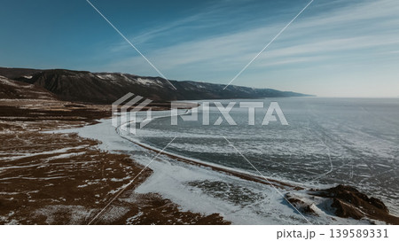 Winter shoreline and frozen water of Lake Baikal, Maloye More aerial panorama 139589331