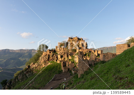 Ruins of the abandoned mountain village of Gamsutl on a rocky ridge at sunset 139589445