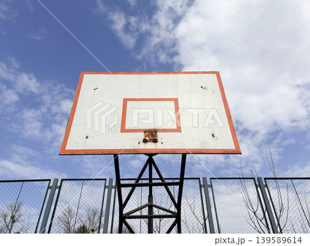 Close-up of a basketball board without a net and a ring. A broken basketball court. Close-up of a basketball board without a net and a ring. A broken basketball court. 139589614