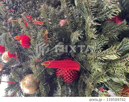 Christmas tree branches with red and gold ornaments, creating a festive seasonal background Christmas tree branches with red and gold ornaments, creating a festive seasonal background 139589782