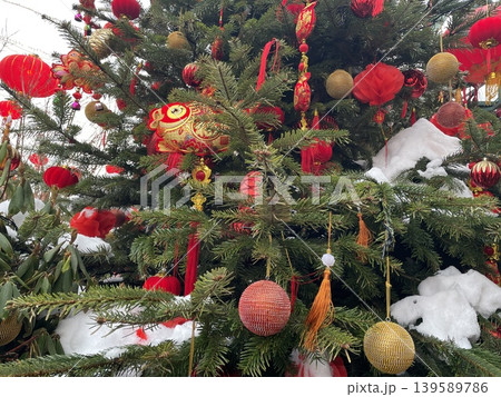 Chinese New Year Christmas tree with red and gold decorations covered in snow 139589786