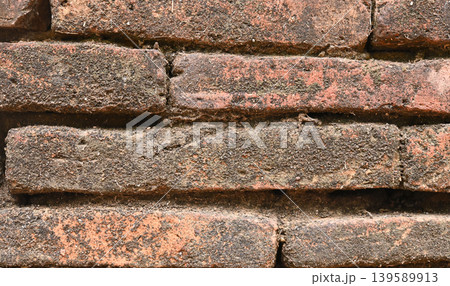 Old orange brick wall texture with vintage character and natural weathered details. Perfect background for design, architecture, rustic themes, or urban style projects.. 139589913