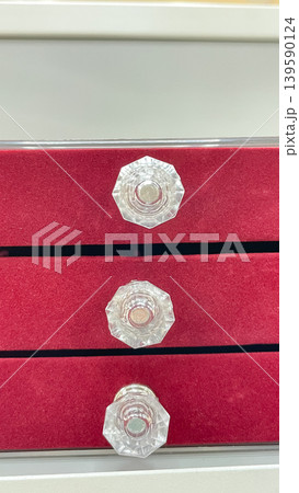 Close up of a red velvet jewelry organizer with three drawers and elegant faceted crystal handles Close up of a red velvet jewelry organizer with three drawers and elegant faceted crystal handles 139590124