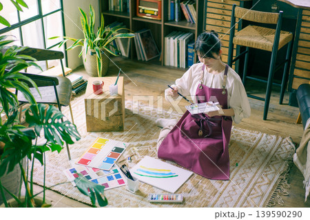リビングの床で絵を描く若い日本人女性 リビングの床で絵を描く若い日本人女性 139590290