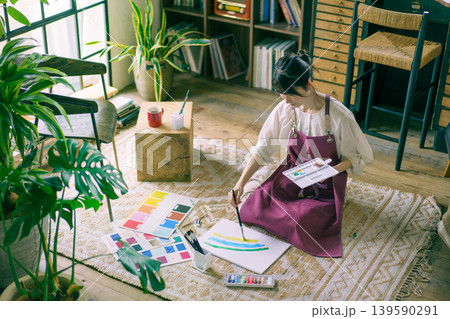 リビングの床で絵を描く若い日本人女性 リビングの床で絵を描く若い日本人女性 139590291