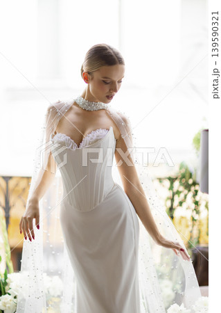 Elegant bride wearing pearl embellished wedding dress and choker 139590321