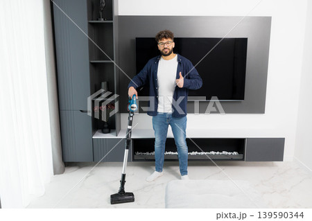 Man holding vacuum cleaner giving thumbs up Man holding vacuum cleaner giving thumbs up 139590344