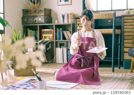 リビングの床で絵を描く若い日本人女性 リビングの床で絵を描く若い日本人女性 139590363