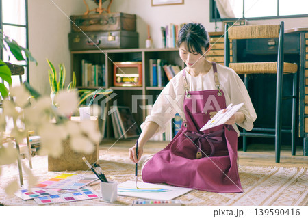 リビングの床で絵を描く若い日本人女性 リビングの床で絵を描く若い日本人女性 139590416
