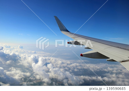 View of Aircraft Wing Over Clouds Prior to Landing 139590685