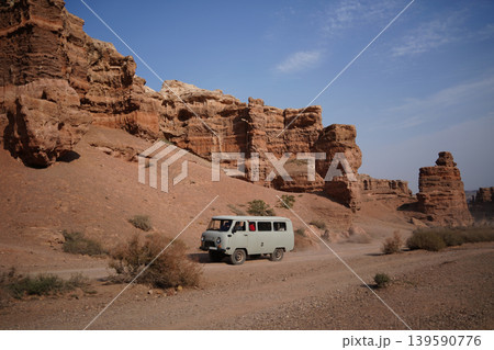 Retro off-road van driving through the majestic Charyn Canyon landscape, Kazakhstan Retro off-road van driving through the majestic Charyn Canyon landscape, Kazakhstan 139590776