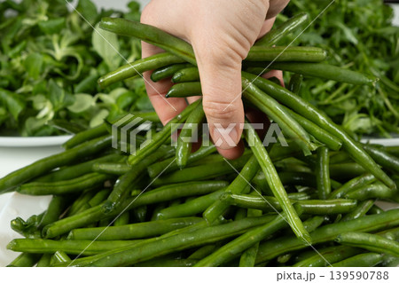 Close up of human hand with raw string beans Close up of human hand with raw string beans 139590788