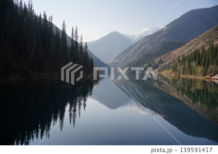 Kolsai Lake in Kazakhstan with forest and mountains reflecting in water Kolsai Lake in Kazakhstan with forest and mountains reflecting in water 139591417