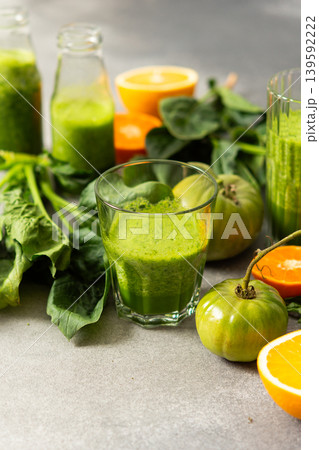 Fresh juice is made using spinach, chard, and broccoli along with oranges and tangerines. A glass of green juice sits by fresh ingredients on a clean kitchen counter Fresh juice is made using spinach, chard, and broccoli along with oranges and tangerines. A glass of green juice sits by fresh ingredients on a clean kitchen counter 139592222