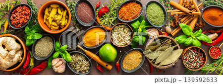 A rich palette of colorful spices and herbs, resting on a brown background, radiating freshness and an inviting aroma, perfect for gourmet inspiration, banner 139592633