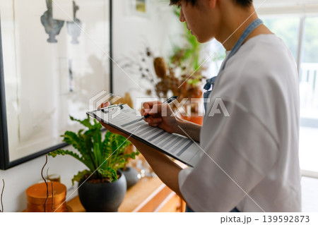 書類に記入する店員 139592873