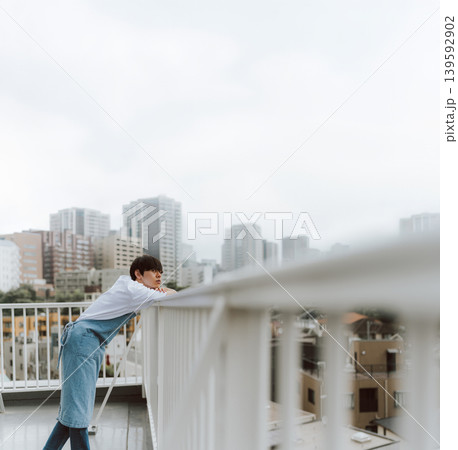 屋上で街を眺める若い男性 139592902