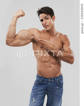 Man, portrait and biceps or bodybuilder pride in studio, wellness and fitness by gray background. Male person, arms and strong or muscular abdomen, confident and results or progress from exercise 139593645