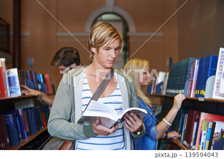 Reading book, knowledge or man in library at university, college or school campus for future education. Bookshelf, focus or male student with scholarship studying research or learning information Reading book, knowledge or man in library at university, college or school campus for future education. Bookshelf, focus or male student with scholarship studying research or learning information 139594043