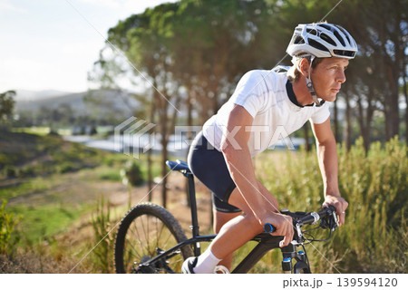 Man, mountain bike and cycling in forest for challenge or outdoor, exercise or athlete. Male person, transportation and off road hill terrain for countryside training or health, workout or adventure 139594120