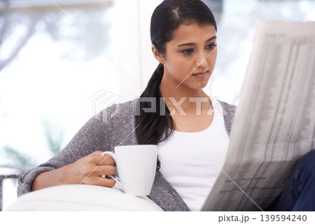 Woman, reading and newspaper with coffee in a home in the morning with story, article and news. Relax, press print and calm person from India with paper publication and tea in house with information 139594240
