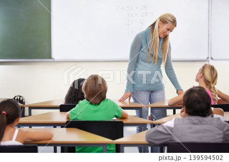 Teacher, kids and students in classroom for learning, education and math support or development at desk. Happy woman with children for teaching numbers, helping with knowledge and questions at school Teacher, kids and students in classroom for learning, education and math support or development at desk. Happy woman with children for teaching numbers, helping with knowledge and questions at school 139594502