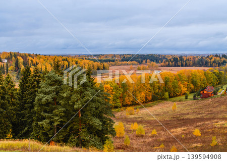 Autumn landscape with vibrant trees and rustic house in a serene countryside setting Autumn landscape with vibrant trees and rustic house in a serene countryside setting 139594908