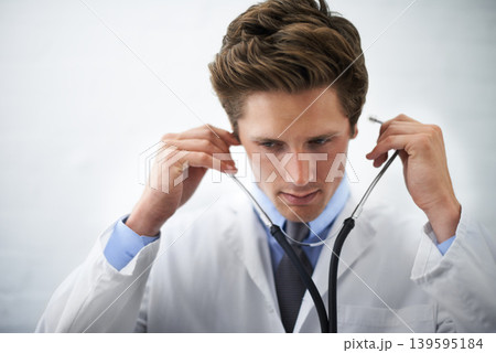 Serious, stethoscope and young doctor with medical career in cardiology at medicare hospital. Doubt, thinking and professional male healthcare worker, employee or intern with equipment in clinic. 139595184