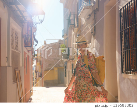 Woman strolls through colorful streets of Spanish coastal town Woman strolls through colorful streets of Spanish coastal town 139595302