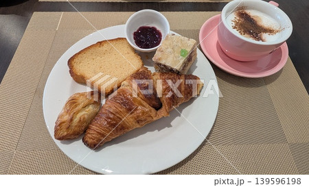 Breakfast plate of croissant, slice of pound cake, and Maltese pastries with a cup of cappuccino Breakfast plate of croissant, slice of pound cake, and Maltese pastries with a cup of cappuccino 139596198