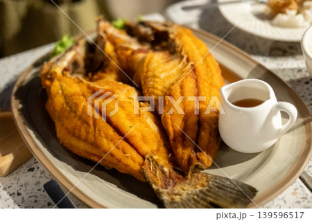 Deep fried Sea bass with Fish Sauce served on plate. Thai food Deep fried Sea bass with Fish Sauce served on plate. Thai food 139596517