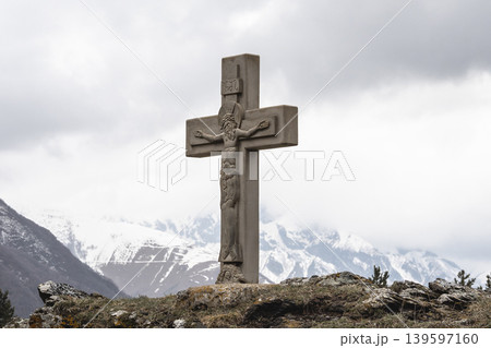 Stone cross stands tall against misty peaks 139597160