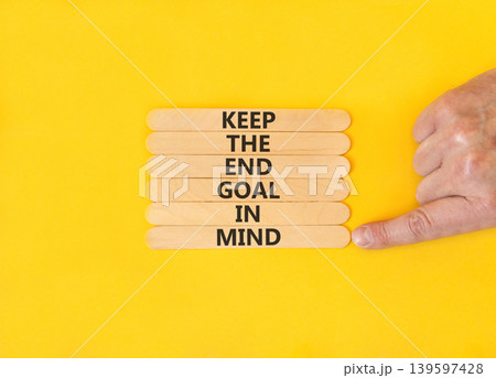 Keep the end goal in mind symbol. Concept words Keep the end goal in mind on beautiful wooden sticks. Beautiful yellow paper background. Business keep the end goal in mind concept. Copy space. 139597428
