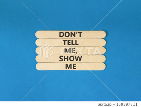 Tell or show symbol. Concept words Do not tell me, show me on beautiful wooden sticks. Beautiful blue paper background. Business tell or show concept. Copy space. Tell or show symbol. Concept words Do not tell me, show me on beautiful wooden sticks. Beautiful blue paper background. Business tell or show concept. Copy space. 139597511