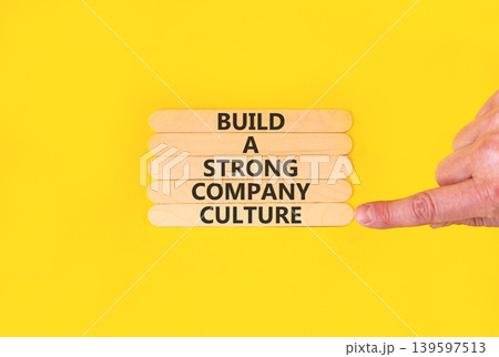 Strong company culture symbol. Concept words Build a strong company culture on beautiful wooden sticks. Beautiful yellow paper background. Business strong company culture concept. Copy space. Strong company culture symbol. Concept words Build a strong company culture on beautiful wooden sticks. Beautiful yellow paper background. Business strong company culture concept. Copy space. 139597513