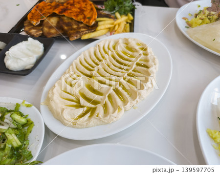 Delicious Hummus Platter with Olive Oil Drizzle and Fresh Ingredients Delicious Hummus Platter with Olive Oil Drizzle and Fresh Ingredients 139597705