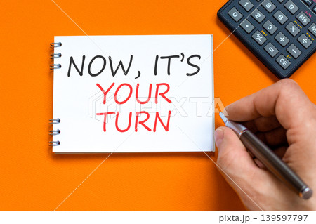 Now it's your turn symbol. Concept words Now it's your turn on beautiful white note. Beautiful orange background. Businessman hand. Business Now it's your turn motivational support concept. Copy space 139597797