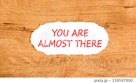 You are almost there words symbol. Concept words You are almost there on beautiful white paper. Beautiful wooden background. Business You are almost there motivational support concept. Copy space. 139597800