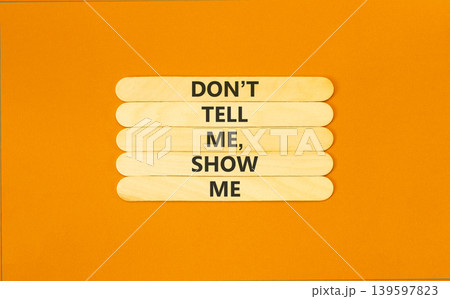 Tell or show symbol. Concept words Do not tell me, show me on beautiful wooden sticks. Beautiful orange paper background. Business tell or show concept. Copy space. 139597823