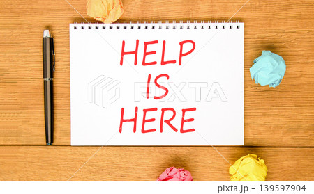 Help is here and support words symbol. Concept words Help is here on beautiful white note. Beautiful wooden background. Black pen. Colored paper. Business help is here and support concept. Copy space. 139597904