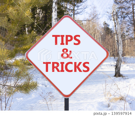 Tips and tricks words symbol. Concept words Tips and tricks on beautiful white road sign. Beautiful winter forest background. Business tips and tricks motivational support concept. Copy space. 139597914