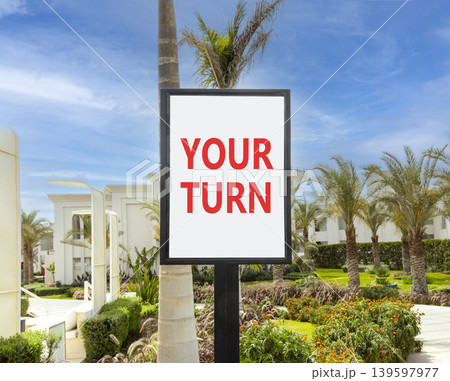 Your turn words symbol. Concept words Your turn on beautiful white sign. Beautiful hotel garden blue sky background. Business your turn motivational support concept. Copy space. Your turn words symbol. Concept words Your turn on beautiful white sign. Beautiful hotel garden blue sky background. Business your turn motivational support concept. Copy space. 139597977