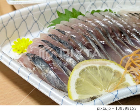 新鮮なアジの刺身 薬味とレモンが添えられた盛り合わせ 新鮮なアジの刺身 薬味とレモンが添えられた盛り合わせ 139598155