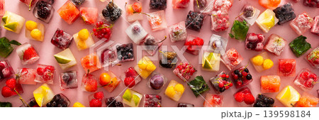 Ice cubes with frozen berries and fruits and mint on a red background, banner Ice cubes with frozen berries and fruits and mint on a red background, banner 139598184