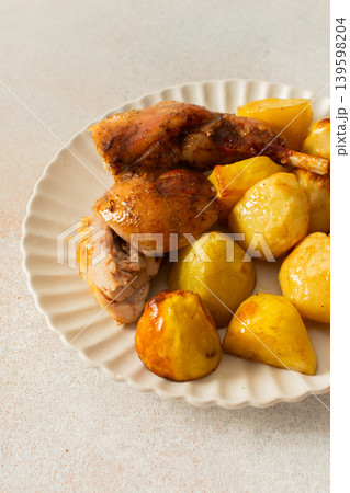A delicious plate showcases a portion of baked rabbit alongside tender, golden roasted potatoes. The rabbit appears well-seasoned, with a crispy skin, while the potatoes are perfectly cooked A delicious plate showcases a portion of baked rabbit alongside tender, golden roasted potatoes. The rabbit appears well-seasoned, with a crispy skin, while the potatoes are perfectly cooked 139598204
