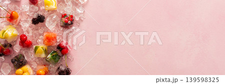 Pink background with ice cubes with frozen berries and fruits and mint, banner Pink background with ice cubes with frozen berries and fruits and mint, banner 139598325