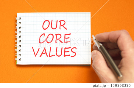 Our core values words symbol. Concept words Our core values on beautiful white note. Beautiful orange background. Businessman hand. Business our core values motivational support concept. Copy space. 139598350