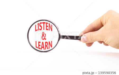 Listen and learn words symbol. Concept words Listen and learn on beautiful magnifying glass. Beautiful white background. Businessman hand. Business listen and learn support concept. Copy space. Listen and learn words symbol. Concept words Listen and learn on beautiful magnifying glass. Beautiful white background. Businessman hand. Business listen and learn support concept. Copy space. 139598356