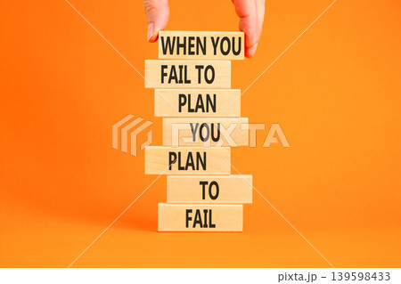 Planning to fail symbol. Concept words When you fail to plan you plan to fail on beautiful wooden blocks. Beautiful orange background. Businessman hand. Business planning to fail concept. Copy space. Planning to fail symbol. Concept words When you fail to plan you plan to fail on beautiful wooden blocks. Beautiful orange background. Businessman hand. Business planning to fail concept. Copy space. 139598433